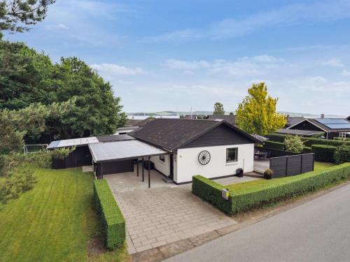 a small white building with a clock on it at Holiday Home Thorward - 100m from the sea by Interhome in Børkop