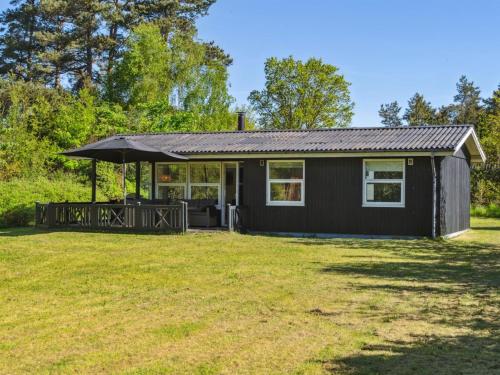 a black tiny house with a large yard at Holiday Home Aldina - 400m to the fjord by Interhome in Havndal