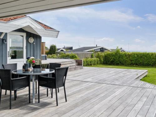 a patio with a table and chairs on a deck at Holiday Home Nahele - 150m from the sea by Interhome in Sønderby