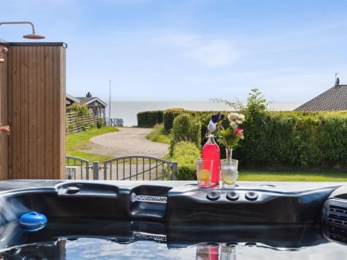 a hot tub with a table with flowers on it at Holiday Home Nahele - 150m from the sea by Interhome in Sønderby