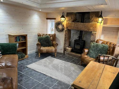 a living room with leather chairs and a fireplace at Cozy Seaside Retreat in Peterhead in Boddam
