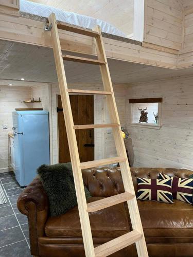 a loft bed in a living room with a couch at Cozy Seaside Retreat in Peterhead in Boddam