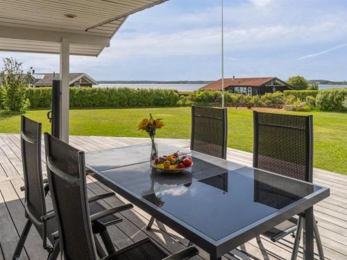 a glass table on a patio with a bowl of fruit at Holiday Home Nahele - 150m from the sea by Interhome in Sønderby