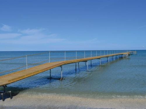 a wooden pier in the water near the beach at Holiday Home Frithbjorn - 900m from the sea by Interhome in Jerup