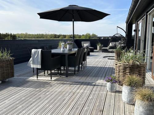 a patio with a table and an umbrella on a deck at Holiday Home Frithbjorn - 900m from the sea by Interhome in Jerup