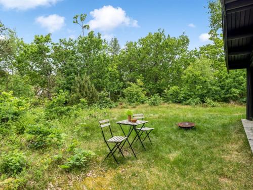a table and chairs in a field with trees at Holiday Home Juho - 700m from the sea by Interhome in Læsø
