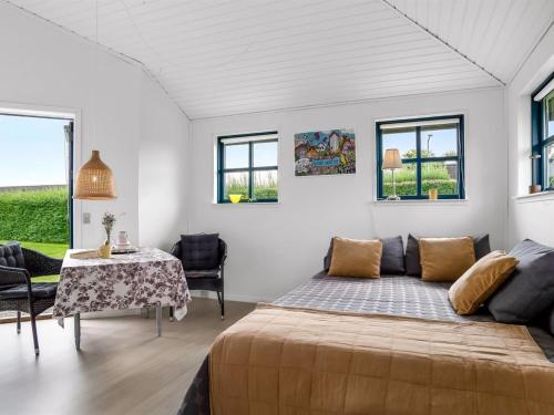 a bedroom with a bed and a table and windows at Apartment Söhnke - 600m from the sea by Interhome in Aså
