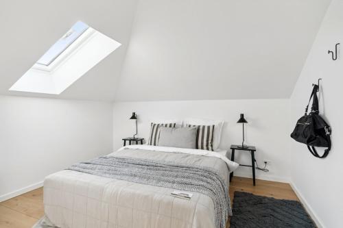 a white bedroom with a bed and a window at Luxury appartment in the embassy-area in Hellerup in Hellerup