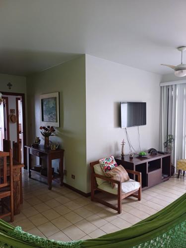 a living room with a chair and a desk at ApUbatuba in Ubatuba