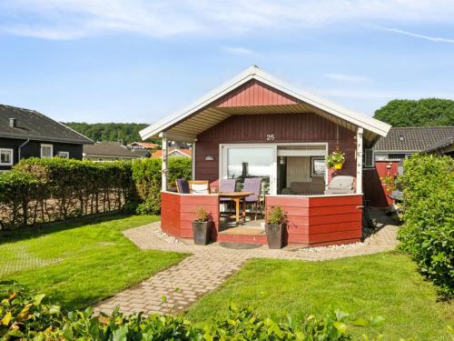 a small house with a table in a yard at Holiday Home Anselmi - 25m from the sea by Interhome in Sjølund