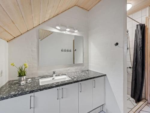 a bathroom with a sink and a mirror at Holiday Home Botmar - 1-5km from the sea by Interhome in Ringkøbing
