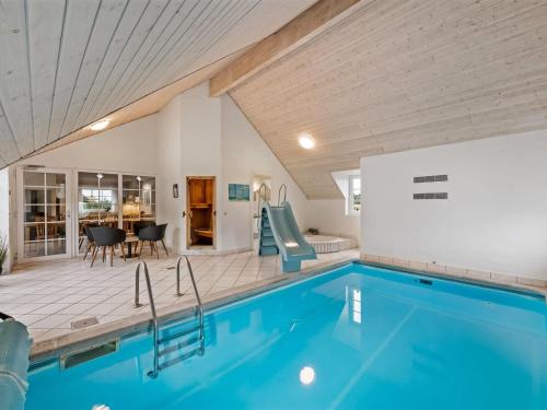 a swimming pool with a slide in a house at Holiday Home Botmar - 1-5km from the sea by Interhome in Ringkøbing