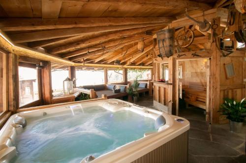 eine Whirlpool-Badewanne in einem Zimmer mit Holzdecken in der Unterkunft Residence Untermösslhof in Lana
