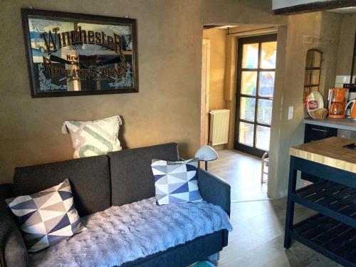 a living room with a couch and a table at OLD TINY HOUSE Laave Ferienwohnung in Laave