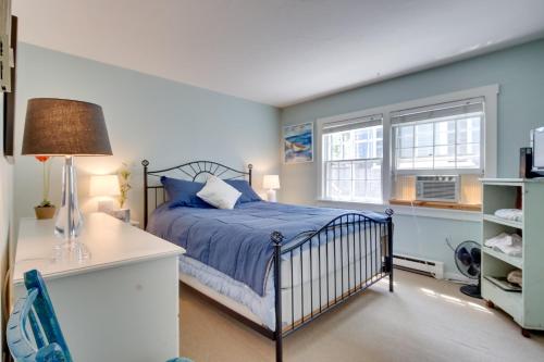 a bedroom with a bed and a desk and two windows at Pool and Beach Access Coastal Condo in Provincetown in Provincetown