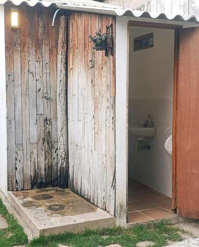 a bathroom with a wooden door and a toilet at Hermoso Palomino in Palomino