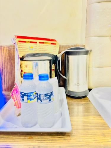 a counter with bottles of water and a coffee pot at Saffron By Family Hotels - Main Market New Delhi in New Delhi