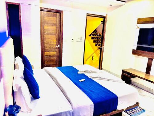 a bedroom with a bed with a blue blanket and a mirror at Saffron By Family Hotels - Main Market New Delhi in New Delhi
