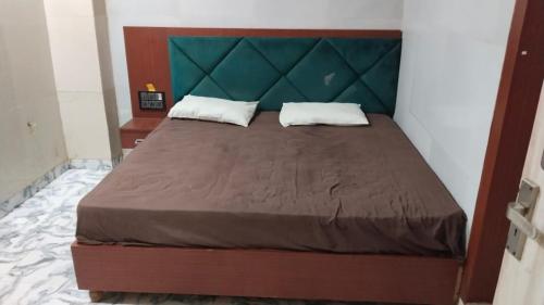 Una cama con dos almohadas encima en una habitación. en Hotel Crystal Blues, en Mathura