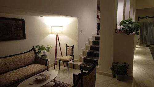 a living room with a couch and a table and stairs at Casa Marcy, casa nueva con alberca y tres recamaras in Pazulco