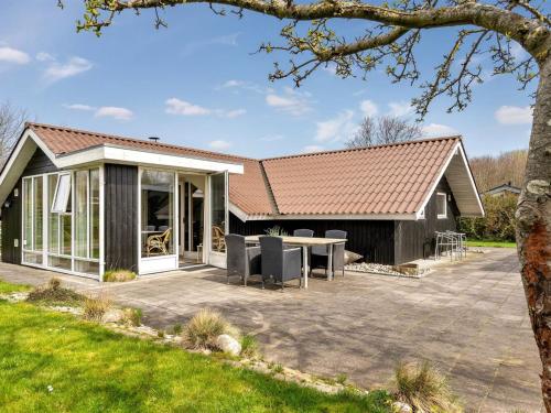 una casa con techo a dos aguas y patio en Holiday Home Magnus - 250m to the fjord by Interhome, en Esbjerg