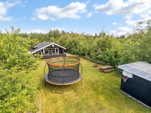 a backyard with a trampoline in the grass at Holiday Home Onni - 2-3km from the sea by Interhome in Saltum