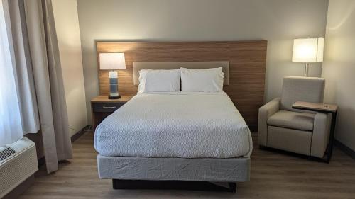 a hotel room with a bed and a chair at Candlewood Suites Conway by IHG in Conway