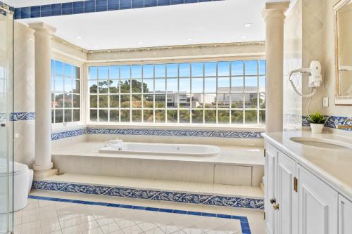 a bathroom with a tub and a large window at MBird 19 Estoril Apartments in Estoril