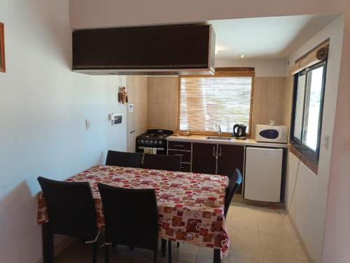 a kitchen with a table and chairs and a kitchen with a sink at Hospedaje Cabañas Costa Tilcara in Tilcara