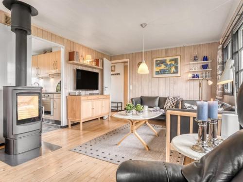 a living room with a couch and a stove at Holiday Home Thorir - 500m from the sea by Interhome in Dannemare