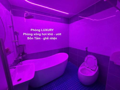 a pink bathroom with a tub and a toilet at Khách Sạn Thu Hà in Ho Chi Minh City