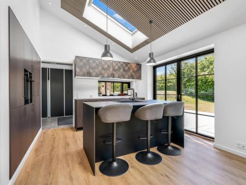 a kitchen with a large island with bar stools at Holiday Home Tähti - 425m from the sea by Interhome in Føllenslev
