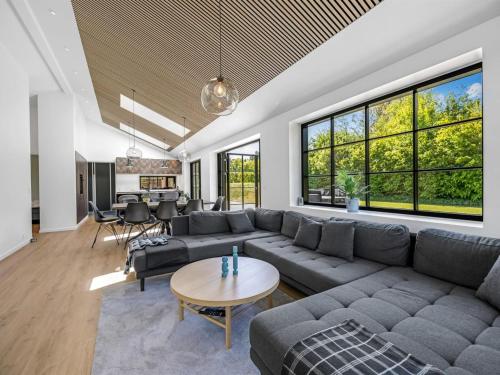 a living room with a couch and a table at Holiday Home Tähti - 425m from the sea by Interhome in Føllenslev