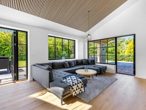 a living room with a couch and a table at Holiday Home Tähti - 425m from the sea by Interhome in Føllenslev