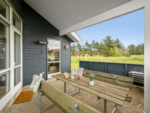 a wooden bench on the back of a house at Holiday Home Felicita - from the sea by Interhome in Ulfborg
