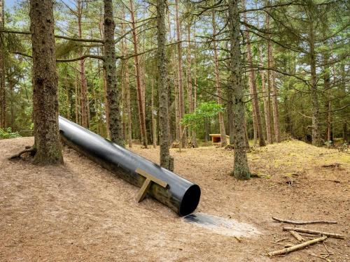 a large cannon sitting in the middle of a forest at Holiday Home Felicita - from the sea by Interhome in Ulfborg