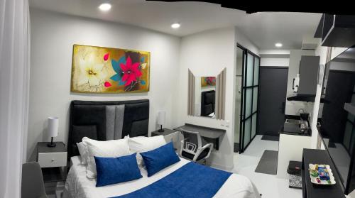 a bedroom with a bed and a painting on the wall at Apartamento en la calle 93 Bogotá Colombia in Estación El Salto