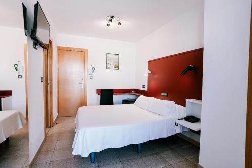 a bedroom with a white bed and a red wall at Hospedium Hotel Continental in Mojácar