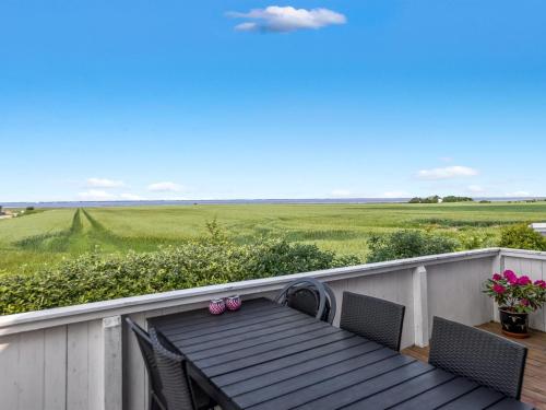 a table and chairs on a balcony with a view of a field at Holiday Home Freja - 12km from the sea by Interhome in Bredebro