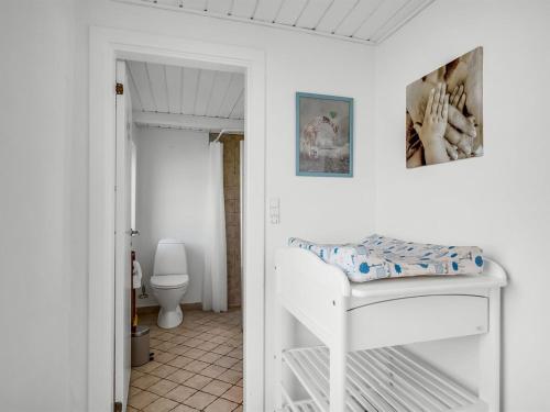 a bathroom with a white bed and a toilet at Holiday Home Brigitte - 1-3km to the fjord by Interhome in Skjern
