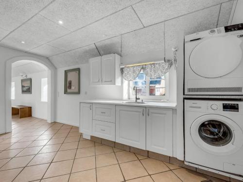 a kitchen with a washing machine and a sink at Holiday Home Brigitte - 1-3km to the fjord by Interhome in Skjern