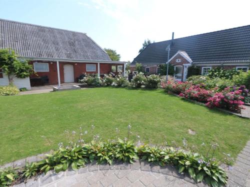 a yard of a house with a lawn with flowers at Holiday Home Brigitte - 1-3km to the fjord by Interhome in Skjern