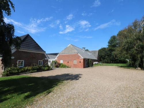 a house with a driveway and a brick building at Holiday Home Brigitte - 1-3km to the fjord by Interhome in Skjern