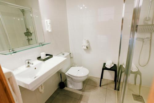 a bathroom with a toilet and a sink and a shower at Hospedium Hotel Continental in Mojácar