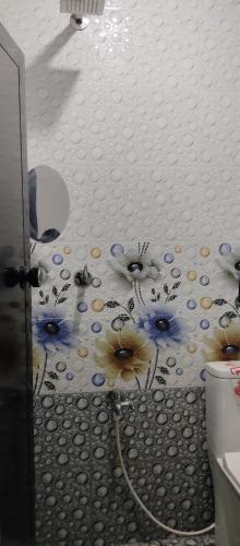 a bathroom with a mural of flowers on the wall at Misty plaza in Munnar
