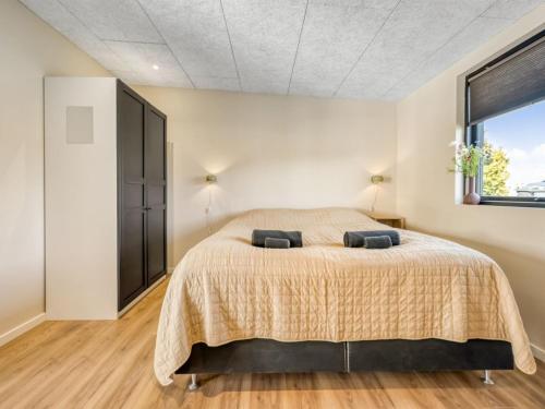 a bedroom with a large bed and a window at Holiday Home Edvia - 200m to the fjord by Interhome in Holbæk
