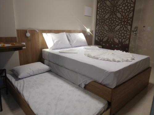two twin beds in a room with at PIAZZA DIROMA FLATS PARA TEMPORADA in Caldas Novas