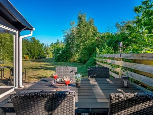 a wooden table with two wine glasses on it at Holiday Home Aamunde - 600m from the sea by Interhome in Ørsted