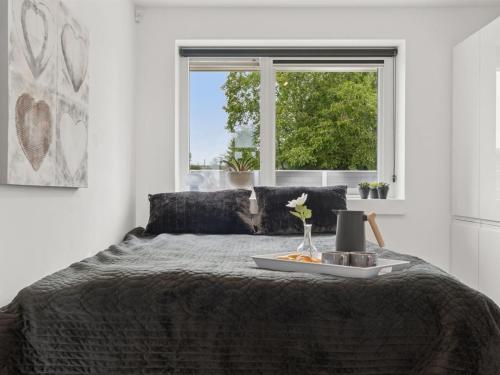 a bedroom with a bed with a window at Holiday Home Thyra - 50m to the inlet by Interhome in Holbæk