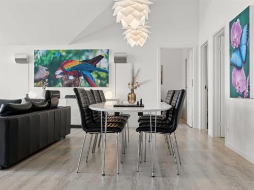 a dining room with a white table and chairs at Holiday Home Thyra - 50m to the inlet by Interhome in Holbæk